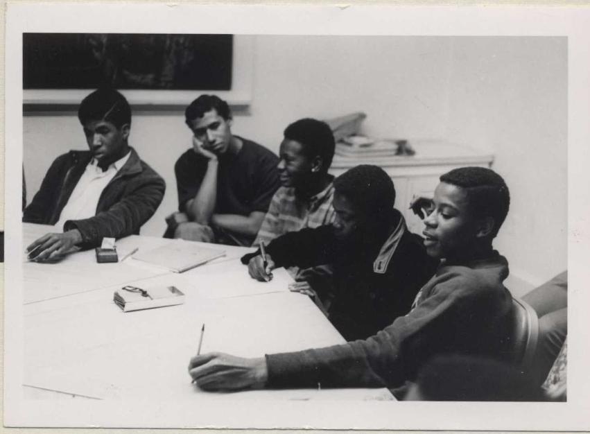 Five teenagers seated around a table.